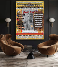 A large framed David Bowie  Tribute painting hangs on a dark gray wall in a modern living room setting with two brown armchairs and floor lamps.