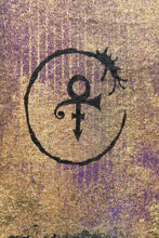 A close-up of a textured surface featuring a black PRINCE symbol combining the Venus symbol with a crescent moon and star, set against a mottled gold and purple background.