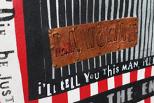 Close-up of a distressed graphic print featuring a copper-colored metal plaque embossed with 'LA WOMAN' on a black and white striped background with red and black text.