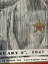 A close-up of a black and white striped graphic print with a gold star containing the text 'IMAN' in red, and a white banner at the bottom reading 'JANUARY 8th, 1947 to Infinite